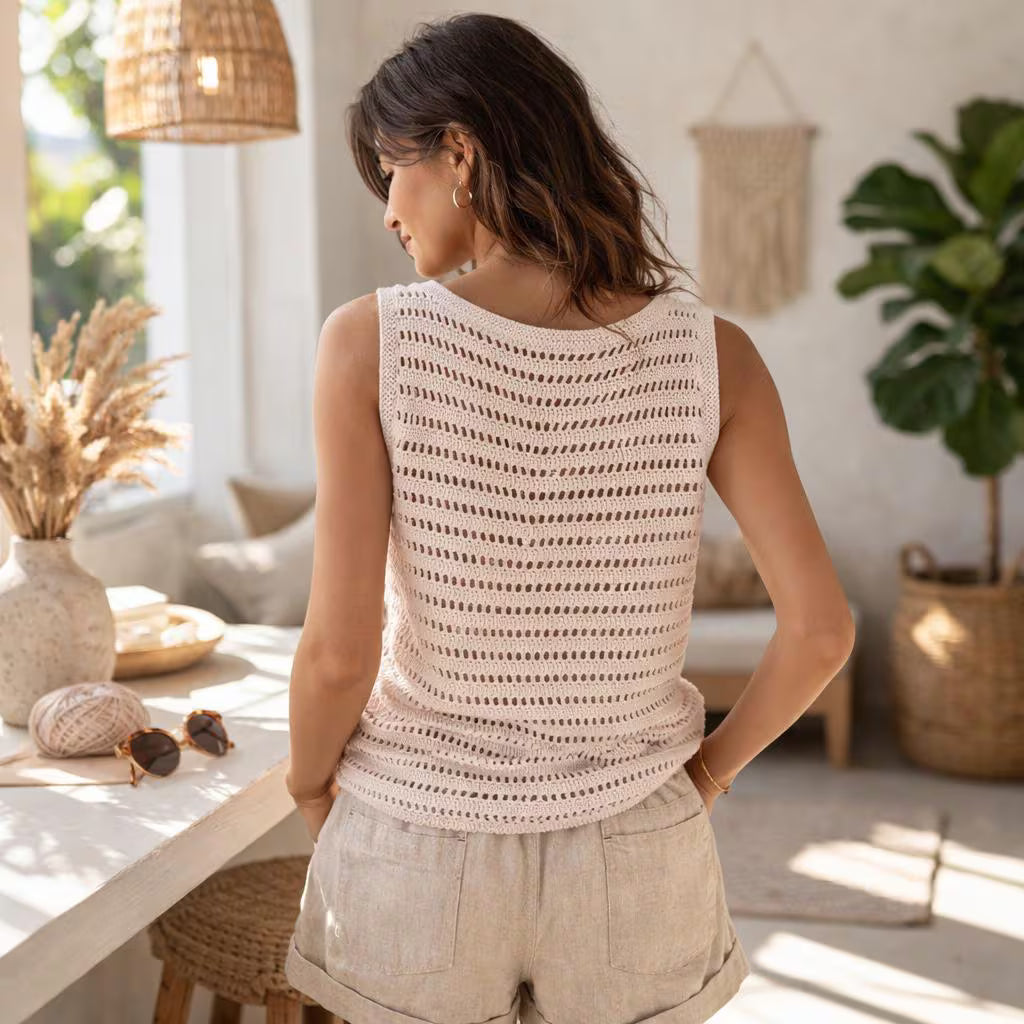 Woman wearing a sleeveless crochet top in a bright, cozy room with plants and decor.